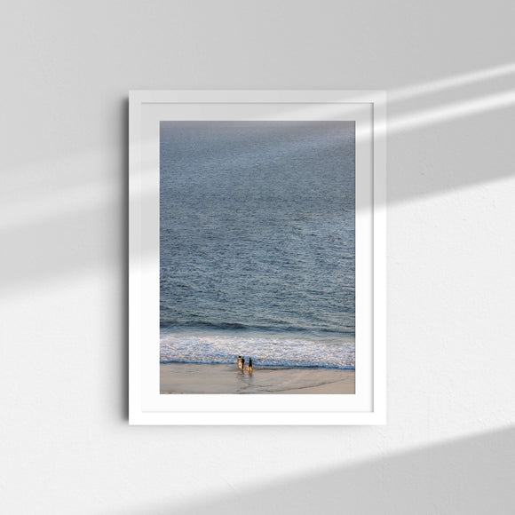 A framed fine art photography print featuring surfers and blue ocean water in Malibu, California.