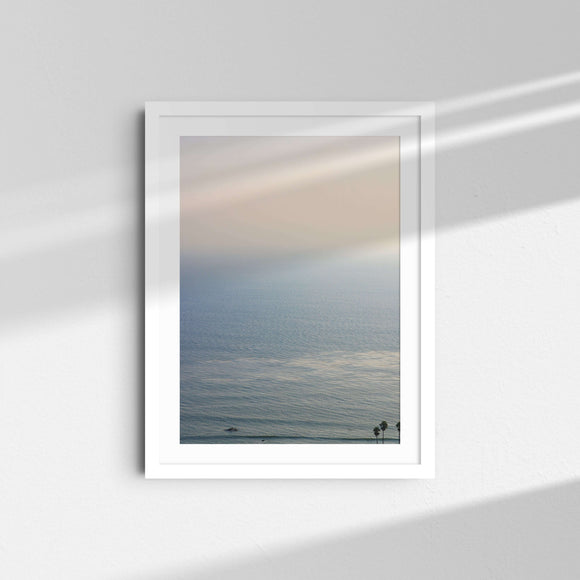 A framed fine art photography print featuring the blue ocean and palm trees in Malibu, California.