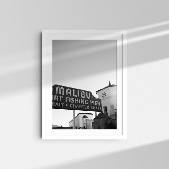 A black and white framed fine art photography print featuring a sign for the Malibu fishing pier.