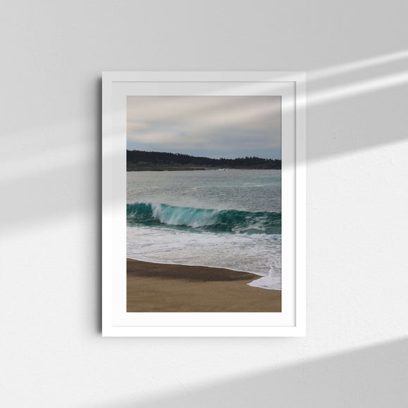 A framed fine art photography print featuring a blue ocean wave in Mara Beach in Carmel-by-the-Sea, California.