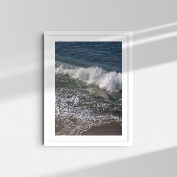 A framed fine art photography print featuring deep blue ocean waves.