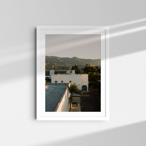 A framed fine art photography print featuring the downtown Santa Barbara city with mountains in the background at sunrise.